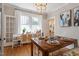 Dining room with a chandelier, wooden table, and decorated table settings, with an adjacent window at 2225 Creston Rd, Raleigh, NC 27608