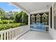 Cozy covered front porch with a blue swing and views of lush greenery at 2225 Creston Rd, Raleigh, NC 27608