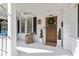 Inviting front porch with swing, white pillars, and door with wreath at 2225 Creston Rd, Raleigh, NC 27608