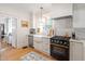 Updated kitchen boasts stainless steel appliances, a farmhouse sink, marble countertops, and a view to the next room at 2225 Creston Rd, Raleigh, NC 27608