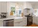 Kitchen with a farmhouse sink, stainless steel appliances, marble counters, and custom white cabinets at 2225 Creston Rd, Raleigh, NC 27608