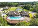 Aerial view highlighting the community clubhouse with pool, seating, and manicured landscaping next to a pond at 2264 Jollay St, Durham, NC 27703