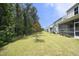 Spacious backyard featuring manicured lawn, mature trees, and new home construction at 2264 Jollay St, Durham, NC 27703