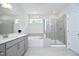 Bright bathroom with a separate tub and shower, gray cabinets, and sleek fixtures at 2264 Jollay St, Durham, NC 27703