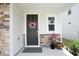 Close-up of the front door with a decorative wreath and a charming stone-accented porch at 2264 Jollay St, Durham, NC 27703