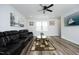 Spacious living room featuring a comfortable black leather sofa, modern decor and ceiling fan at 2264 Jollay St, Durham, NC 27703