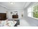 Bright main bedroom featuring neutral walls, tray ceiling, carpet floors, and a view to the ensuite bathroom at 2264 Jollay St, Durham, NC 27703