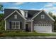 Charming gray home featuring stone accents, a two-car garage, and professionally landscaped yard at 237 Tidal Pool Way, Cary, NC 27519