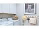 Bright laundry room with white cabinets, modern washer and dryer, and stylish decorations at 237 Tidal Pool Way, Cary, NC 27519