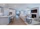 Open-concept living room featuring a modern kitchen, comfortable seating, and a cozy fireplace at 237 Tidal Pool Way, Cary, NC 27519