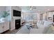 Elegant living room featuring a fireplace, large TV, modern decor, and comfortable white sofa at 237 Tidal Pool Way, Cary, NC 27519