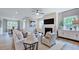 Bright living room with plush seating, a cozy fireplace, and large windows providing natural light at 237 Tidal Pool Way, Cary, NC 27519