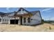 New home construction shows Tyvek wrap and framing with the new roof and covered porch at 2400 Fleming Stone Ln # 52, Raleigh, NC 27610