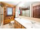 Bathroom featuring wood paneled walls, dual sinks, and a shower and tub combo with glass doors at 2416 Kearney Rd, Wake Forest, NC 27587