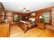 Spacious bedroom boasts wood paneling, a ceiling fan, and ample natural light from the two windows at 2416 Kearney Rd, Wake Forest, NC 27587