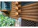 Close-up shows the foundation and logs of this log home, nestled in lush greenery at 2416 Kearney Rd, Wake Forest, NC 27587