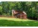 Stunning exterior elevation showcasing the back of the home with lush lawn, mature trees, and private deck at 2416 Kearney Rd, Wake Forest, NC 27587