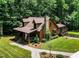 Charming log home with stone chimney, landscaped yard, and inviting front porch with the American flag at 2416 Kearney Rd, Wake Forest, NC 27587