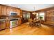 Charming eat-in kitchen featuring wood cabinets, stainless steel appliances, and wood-paneled walls at 2416 Kearney Rd, Wake Forest, NC 27587