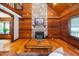 Bright living room with wood paneling, stone fireplace, and rustic beams, filled with natural light at 2416 Kearney Rd, Wake Forest, NC 27587
