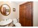 Charming powder room featuring a pedestal sink, oval mirror, and a rich, wood-paneled closet at 2416 Kearney Rd, Wake Forest, NC 27587