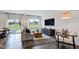 Living room with hardwood floors, a sofa, a modern console table, and large windows at 2728 Sammish Way, Raleigh, NC 27616