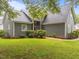 Inviting home exterior showcasing lush landscaping, stone walkway, and gray vinyl siding at 2913 Coxindale Dr, Raleigh, NC 27615