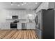 Modern kitchen features stainless steel appliances, white cabinetry, and wood flooring at 2913 Coxindale Dr, Raleigh, NC 27615