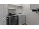 This laundry room features a front-load washer and a dryer with white cabinets above at 2913 Coxindale Dr, Raleigh, NC 27615