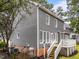 Gray home's rear exterior showcases a cozy deck, access stairs, and well-kept yard at 2913 Coxindale Dr, Raleigh, NC 27615