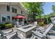 Backyard patio features a stone fire pit and Adirondack chairs, red umbrella, and rear house architecture at 308 W Whitaker Mill Rd, Raleigh, NC 27608