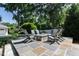 Backyard patio with stone pavers, a stone fire pit, and several Adirondack chairs, perfect for outdoor entertaining at 308 W Whitaker Mill Rd, Raleigh, NC 27608