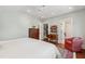 Bright bedroom featuring hardwood floors, a colorful rug, a ceiling fan, and an accent chair at 308 W Whitaker Mill Rd, Raleigh, NC 27608
