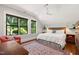 Inviting bedroom with large windows, hardwood floors, a ceiling fan, and a cozy reading nook at 308 W Whitaker Mill Rd, Raleigh, NC 27608