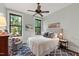 Comfortable bedroom with large windows, ceiling fan, and a patterned accent rug at 308 W Whitaker Mill Rd, Raleigh, NC 27608