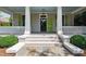 Inviting front porch with gray flooring, white railings, and a dark door with green shutters at 308 W Whitaker Mill Rd, Raleigh, NC 27608