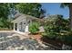 The property features a detached garage with white doors and columns and well manicured landscaping around the perimeter at 308 W Whitaker Mill Rd, Raleigh, NC 27608