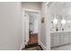 Hallway leading to a bright bathroom with a double sink vanity at 308 W Whitaker Mill Rd, Raleigh, NC 27608