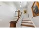 Bright staircase with wood treads and white risers ascends beneath natural light, accented by tasteful wall art at 308 W Whitaker Mill Rd, Raleigh, NC 27608