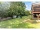 This backyard features a large grassy area, various sheds, and wooded surroundings at 3298 Oakridge Dr # A, Graham, NC 27253