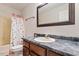 This bathroom features a tile countertop, a large mirror, and a shower with a decorative curtain at 3298 Oakridge Dr # A, Graham, NC 27253