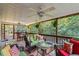 This screened deck features wood floors, wicker furniture, and a view of the wooded yard at 3298 Oakridge Dr # A, Graham, NC 27253