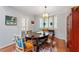 Cozy dining room with a decorative light fixture, shuttered windows, and hardwood floors at 352 Weymouth Close, Pittsboro, NC 27312