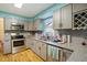 Well-lit kitchen featuring granite countertops, gray cabinets and modern stainless steel appliances at 3712 Old Coach Rd, Raleigh, NC 27616