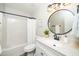 Bathroom featuring modern fixtures, a round mirror, and a tub with shower at 401 Wyndham Drive, Fuquay Varina, NC 27526