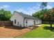 Back exterior view of home, with white siding, well maintained lawn, and mature trees at 401 Wyndham Drive, Fuquay Varina, NC 27526