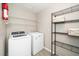 Functional laundry room featuring a washer, dryer, and storage shelving at 401 Wyndham Drive, Fuquay Varina, NC 27526