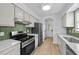 Modern kitchen featuring stainless steel appliances, white cabinets, and quartz countertops at 413 Top Greene Ln, Raleigh, NC 27601