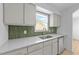 Bright kitchen features stainless steel appliances, ample counter space, and decorative green tile backsplash at 413 Top Greene Ln, Raleigh, NC 27601