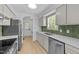 Modern kitchen featuring stainless steel appliances, white cabinets, and tile backsplash at 413 Top Greene Ln, Raleigh, NC 27601